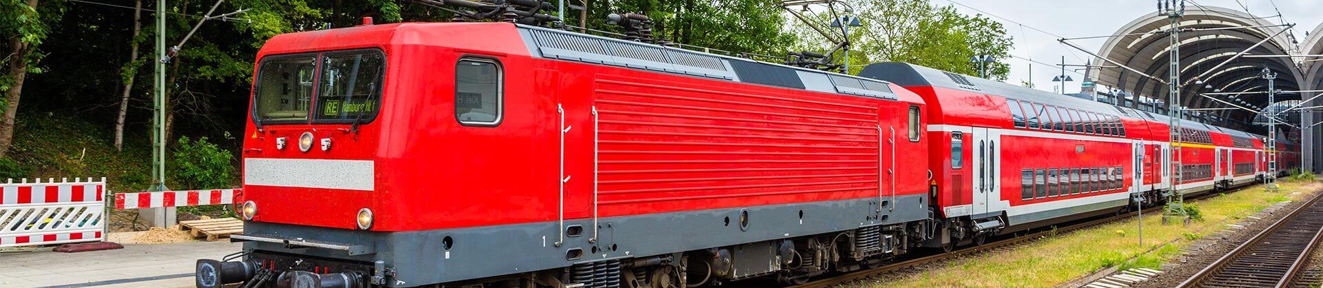 Rote Lokomotive am Bahnhof – Schienenfahrzeuge finanzieren